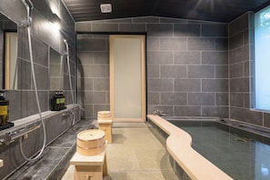 Casa de banho moderna com banheira, chuveiro e toucador com artigos de higiene pessoal.