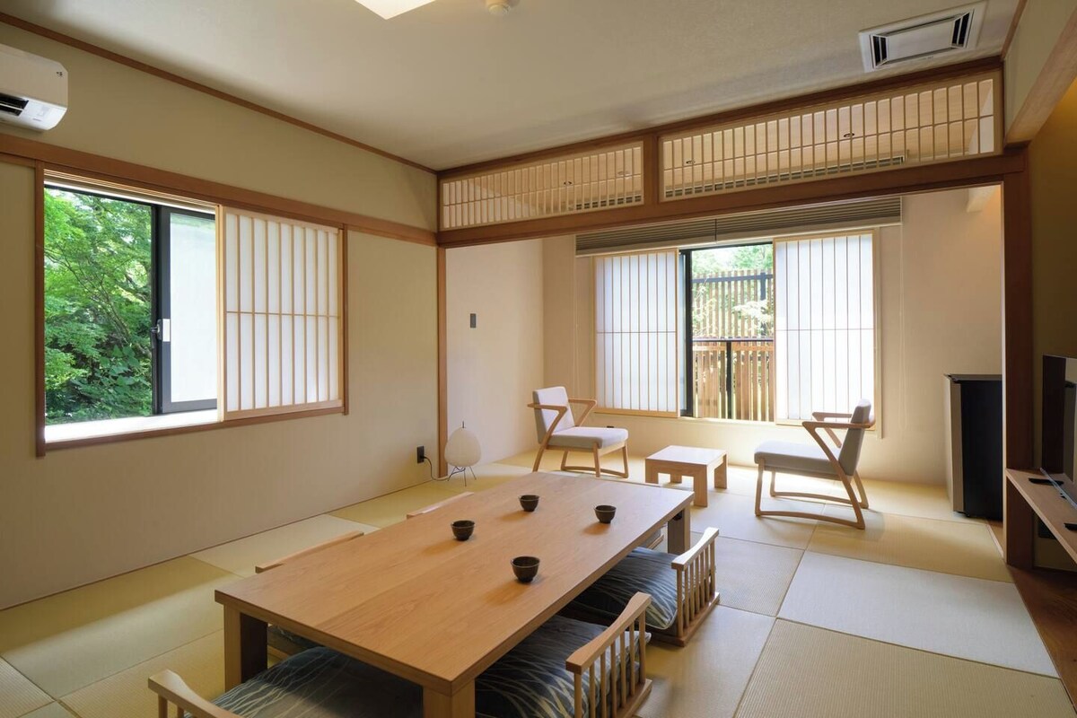 Um quarto em estilo japonês tradicional, com tatames, uma mesa baixa e portas deslizantes shoji.