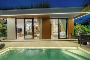 A modern house with a swimming pool, large glass doors leading to a living area, and a dining area. - Brand New Villa+Huge Pool+Beach Access+South Kuta (Badung Regency)
