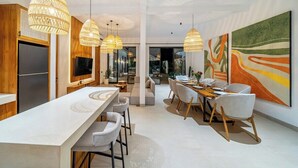 Una cocina moderna con una encimera larga y luces colgantes.