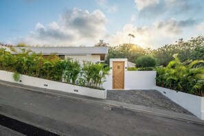 A modern house with a white exterior, a wooden door, and a paved driveway. - New 1BR Villa+Beach Access+Private Pool+South Kuta (Badung Regency)