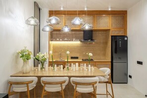 A modern kitchen with a central island, pendant lights, and a built-in stove. - New 1BR Villa+Beach Access+Private Pool+South Kuta (Badung Regency)