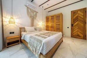Een slaapkamer met een bed, nachtkastjes, een kledingkast en wandlampen.