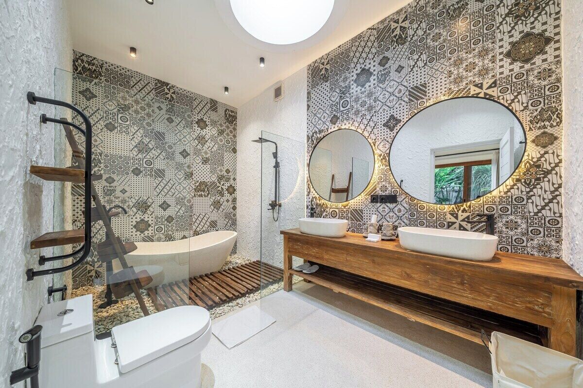 A modern bathroom with a freestanding bathtub, a wooden vanity with two sinks, and a large mirror above the vanity.