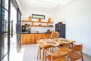 Eine moderne Küche mit Holzschnitzereien, einem eingebauten Backofen und einer Essecke mit einem Holztisch und Stühlen.