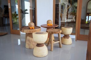 Eine Gruppe hölzerner Hocker mit ungewöhnlichem Design auf einem Fliesenboden.