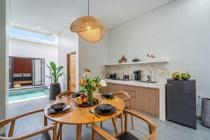 Eine moderne Küche mit Essbereich, einem Pool und einem Wohnzimmer mit einem Bett.