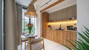 Eine moderne Küche mit Holzausstattung, einem Einbauofen und einem Essbereich mit Tisch und Stühlen.