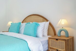 A bed with a wooden headboard, white bedding, and a teal throw blanket. There are two bedside tables with lamps. - Brand new private villa, large pool, beach access (Kabupaten Badung)