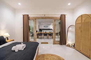 A modern hotel room with a bed, a dining area, and a mirror. - Brand new private villa, large pool, beach access (Kabupaten Badung)