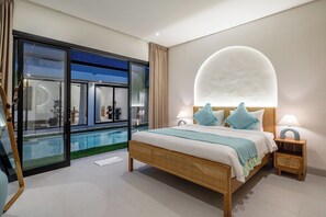 A modern bedroom with a large bed, a glass door leading to a pool, and a unique ceiling light fixture. - New Designer 2BR Villa+Huge Pool+Central Location (Kuta Utara)