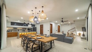 Una cucina moderna con zona pranzo, un divano grigio e una scala.