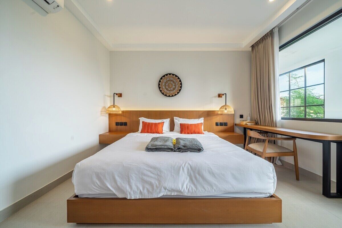 A hotel room with a large bed, a desk, and a view of the outdoors.