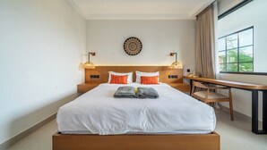Camera d'albergo con un letto grande, una scrivania e vista sull'esterno.
