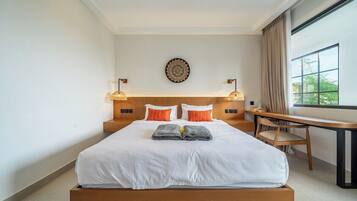 A hotel room with a large bed, a desk, and a view of the outdoors.