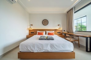 A hotel room with a large bed, a desk, and a view of the outdoors. - Serene 3BR Escape w Beach Nearby, Huge Pool&Garden (Kabupaten Badung)