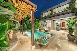 A modern house with a swimming pool, outdoor seating, and lush greenery. - Serene 3BR Escape w Beach Nearby, Huge Pool&Garden (Kabupaten Badung)