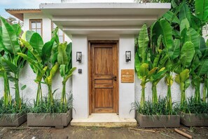 Una puerta de madera con una pared blanca y un letrero que dice 'Tropical Tribe Villa'.