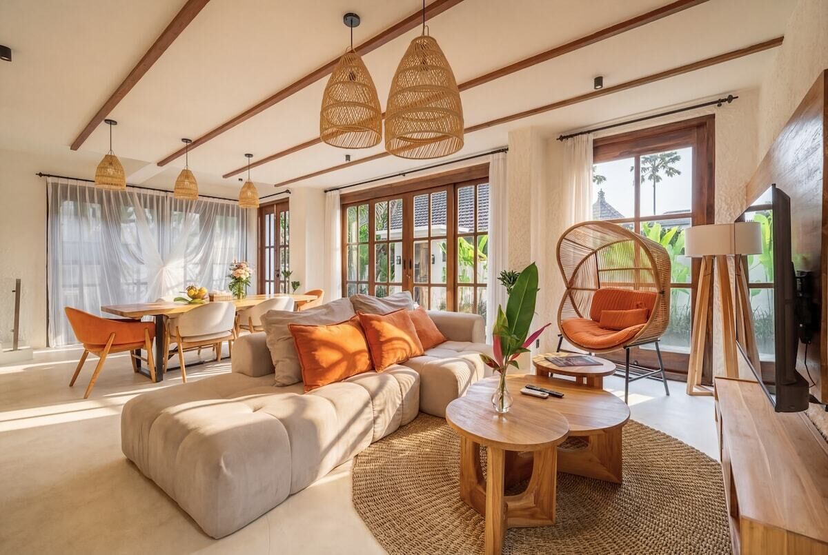 Una sala moderna con un sofá, un comedor y una silla colgante.