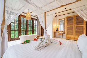 Ein Schlafzimmer mit einem großen Bett, einer Badewanne und einem Holzschrank.