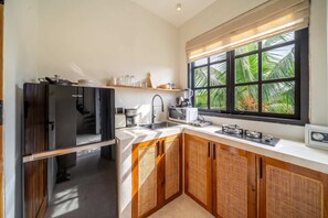 A compact kitchen with a built-in oven, a coffee maker, and a microwave. - Serene 1BR Escape in Ubud w Pool, Patio & Garden (Gianyar Regency)