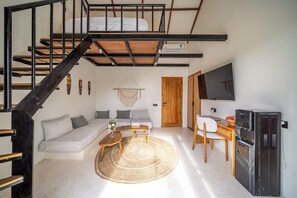 A compact living space with a bunk bed, a sofa, a coffee table, a TV, and a kitchenette. - Serene 1BR Escape in Ubud w Pool, Patio & Garden (Gianyar Regency)