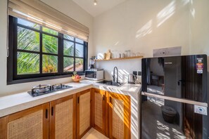 Una cucina moderna con piano cottura a gas, forno a microonde e frigorifero.