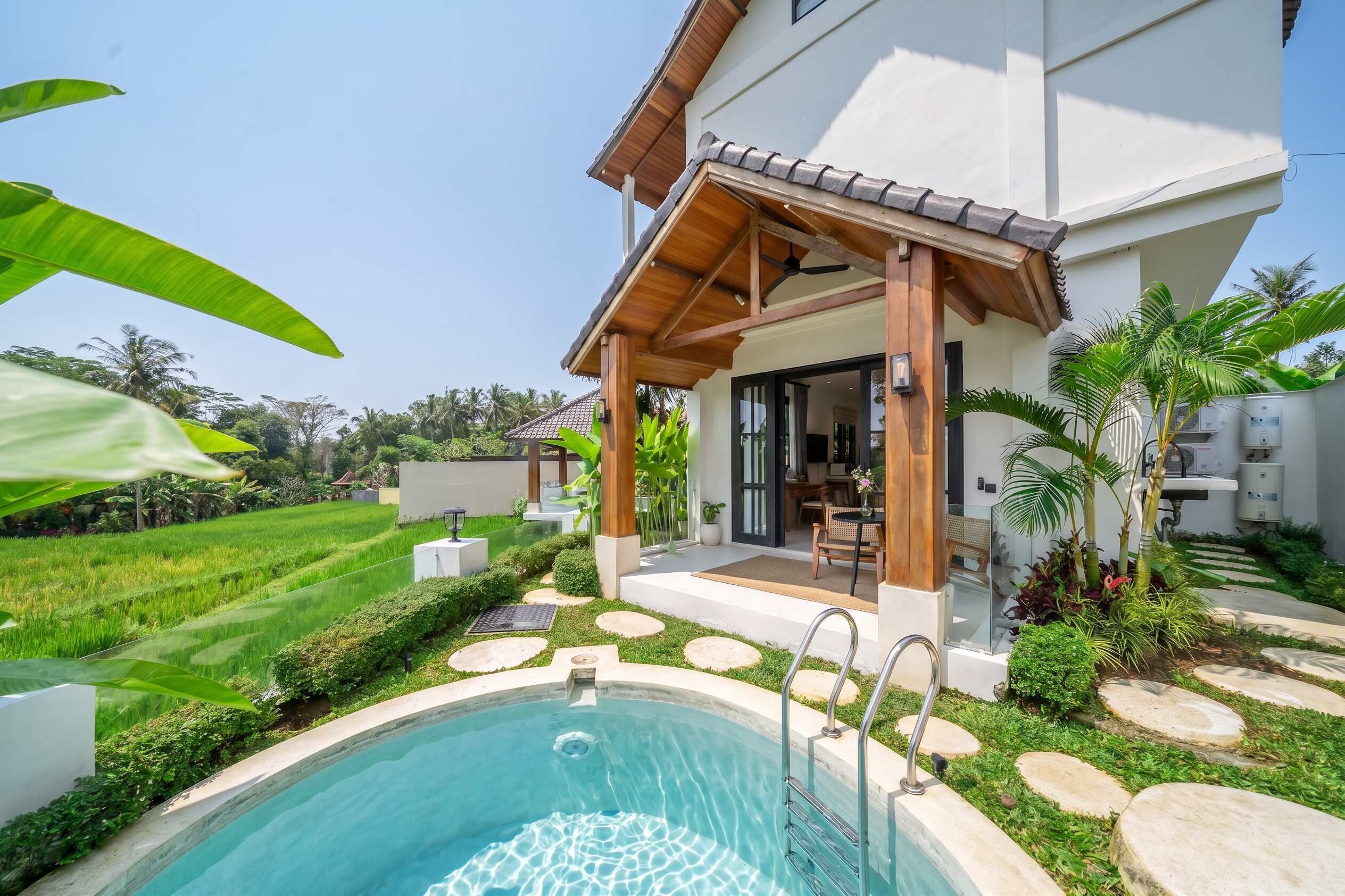 A modern house with a pool, covered patio, and lush garden.