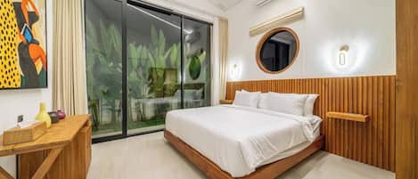 Un dormitorio moderno con una cama grande, una mesita de noche de madera, una puerta de cristal que da a un jardín y un espejo redondo en la pared.
