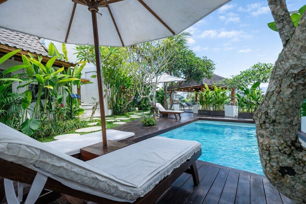 A poolside area with lounge chairs and a pergola.