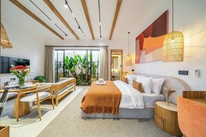 A modern hotel room with a bed, a dining area, and a TV. - Chic Cozy 1BR in Prime Ubud w Pool, Garden & Patio (Ubud)