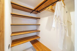 A wooden staircase with a metal handrail and a white wall with a hanging garment rack. - Stylish 2BR w Garden Bath & Pool, Top Ubud's Spot (Kabupaten Gianyar)