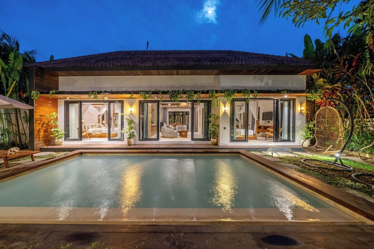 A modern house with a swimming pool, large windows, and outdoor seating.