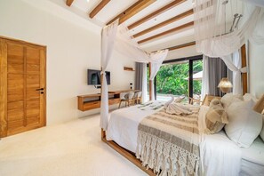 A bedroom with a canopy bed, a desk, and a television. - Stylish 2BR w Garden Bath & Pool, Top Ubud's Spot (Kabupaten Gianyar)