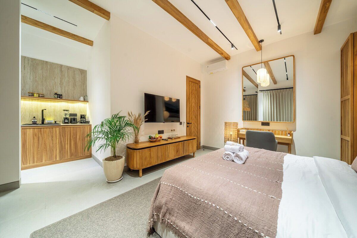 Una habitación de hotel moderna con cama, televisor, escritorio y baño.