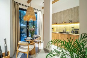 Une cuisine moderne avec des meubles en bois, un four encastré et un plan de travail équipé de divers appareils électroménagers.