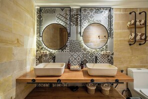 Ein Badezimmer mit zwei Waschbecken, einem Spiegel und einer Badewanne.