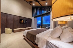 Ein modernes Schlafzimmer mit einem großen Bett, einem Fernseher und Blick ins Freie.