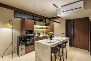 A modern kitchen with a central island, built-in appliances, and a dining area. - Badung's Best Stylish 1BR - Beaches Nearby+Pool (Badung Regency)
