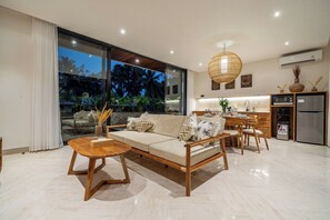 A modern living room with a sofa, coffee table, and dining area. - Tranquil 3BR Hideaway in Central Ubud • Huge Pool (Gianyar Regency)