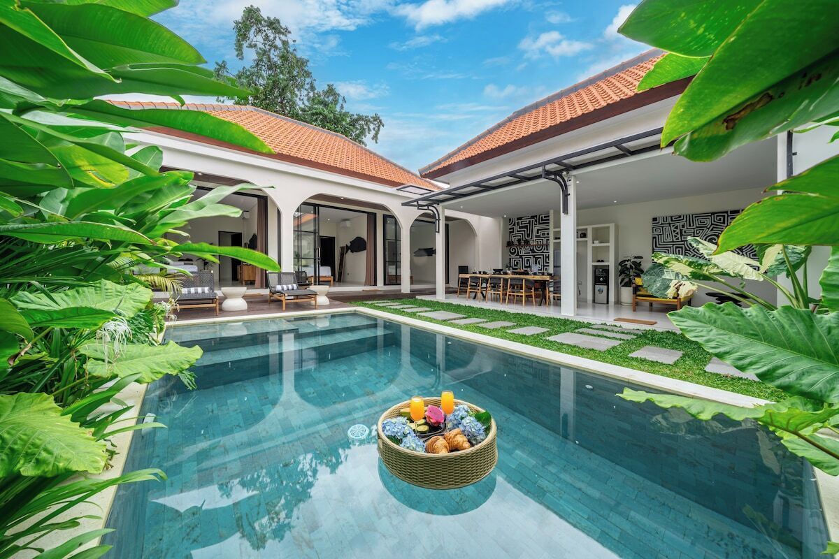 A swimming pool with a basket of fruits and a covered patio area.