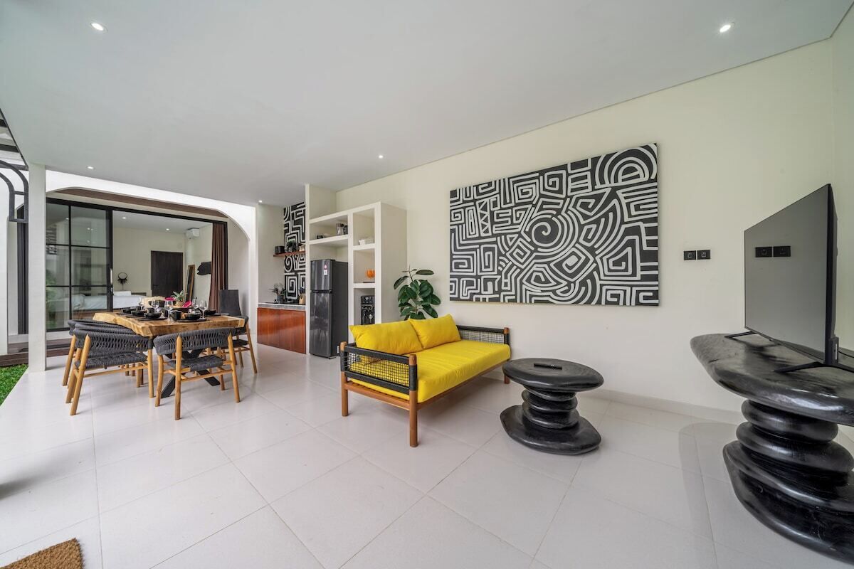 A modern living room with a dining area, a sofa, a coffee table, and a TV.