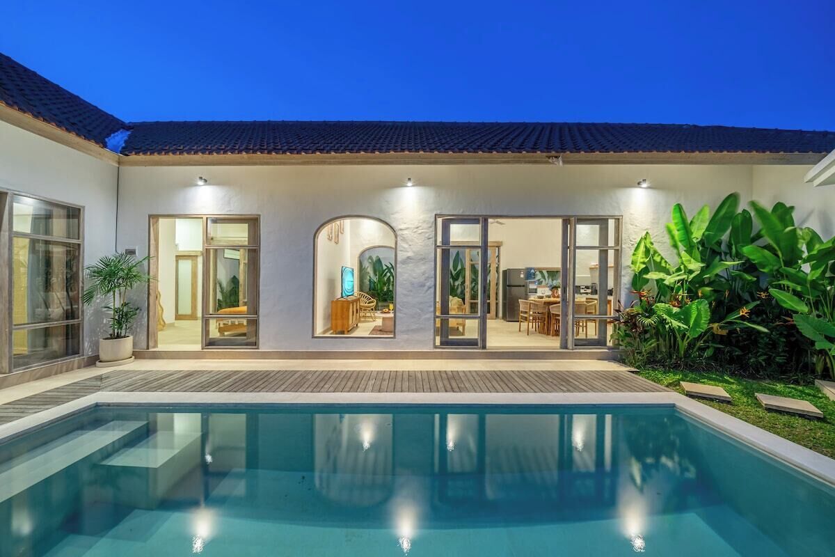 A residential property with a swimming pool, a covered patio, and a dining area.