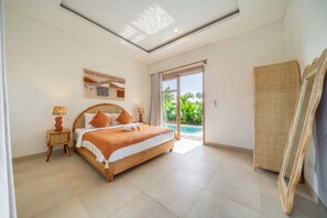 Ein Schlafzimmer mit einem Bett, Nachttischen, einem großen Fenster und Blick ins Freie.