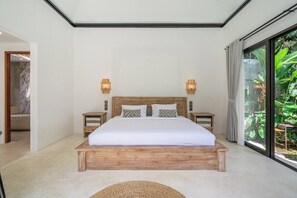 A bedroom with a wooden bed, two bedside tables, and a view of greenery through a large window. - Cozy 2BR in Ubud w Rice Field&Temple Views+Pool (Kecamatan Ubud)