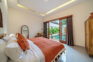 Une chambre d’hôtel avec un lit, une armoire en bois, une grande fenêtre avec des rideaux et une vue sur l’extérieur.