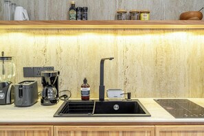 A kitchen with a built-in stove, a coffee maker, a toaster, and a sink. - Cozy 1BR • Pool&Garden View • Patio • Central Ubud (Kabupaten Gianyar)