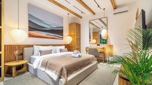 A modern hotel room with a large bed, bedside tables, a desk, and a mirror. - Cozy 1BR • Pool&Garden View • Patio • Central Ubud (Kabupaten Gianyar)