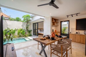 A modern interior with a dining area, a pool, and a kitchen. - Paradise 2BR Villa w Beach Access & Private Pool (Kecamatan Kuta Utara)