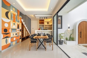Ein modernes Interieur mit Essbereich, Treppe und Blick ins Freie.